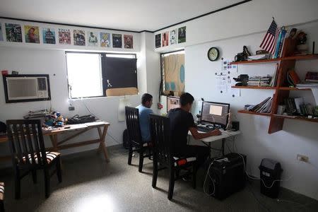 Robin Pedraja, 29 (R), editor of the digital magazine Vistar, works at his office in Havana, Cuba, August 11, 2016. REUTERS/Alexandre Meneghini/Files