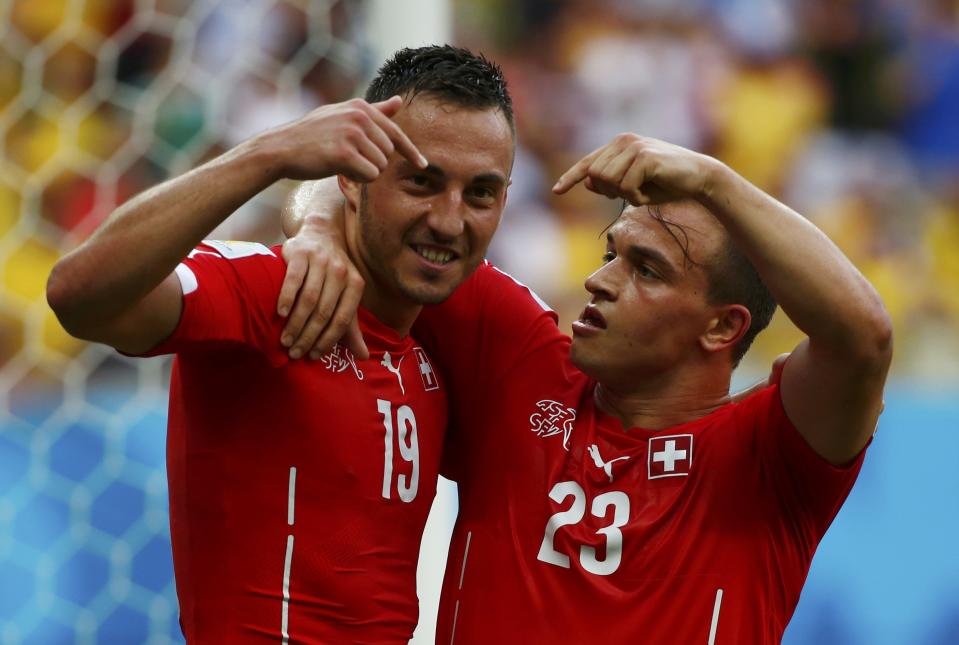 Switzerland's Xherdan Shaqiri (R) celebrates with Josip Drmic after scoring against Honduras during their 2014 World Cup Group E soccer match at the Amazonia arena in Manaus June 25, 2014. REUTERS/Michael Dalder (BRAZIL - Tags: SOCCER SPORT WORLD CUP)