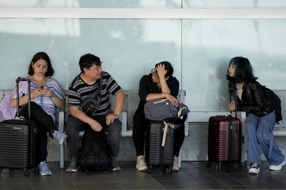 Tourists from Chile sit outside the Jorge Newbery airport after their flight was suspended in Buenos Aires, Argentina, Wednesday, Feb. 28, 2024. Airport and airline workers, as well as pilots, are staging a 24-hour strike for improved wages. (AP Photo/Natacha Pisarenko)