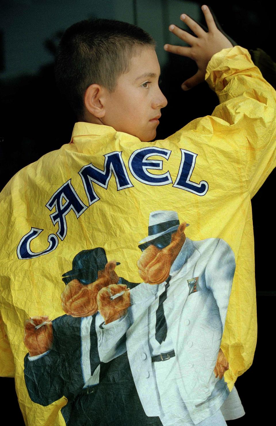 Michael Mendoza, 12, models a promotional jacket featuring "Joe Camel" of the Camel cigarette company, July 20, 1995, in Atlanta. The U.S. government blamed the surge in teens who took up smoking in the 1980s on massive promotional campaigns by tobacco companies.