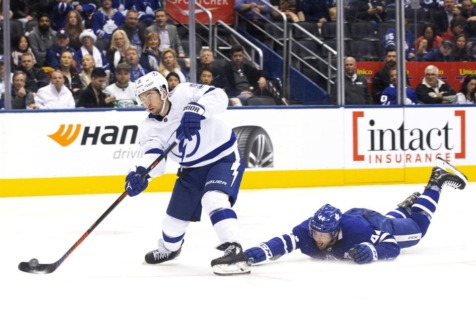 Tampa Bay Lightning center Tyler Johnson (9) gets a shot away as Toronto Maple Leafs defenseman Morgan Rielly (44) defends during the second period of an NHL hockey game Tuesday, March 10, 2020, in Toronto. (Chris Young/The Canadian Press via AP)