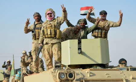 Iraqi forces show victory signs after they captured Rawa town, the last remaining town under Islamic State control, Iraq November 17, 2017. REUTERS/Stringer