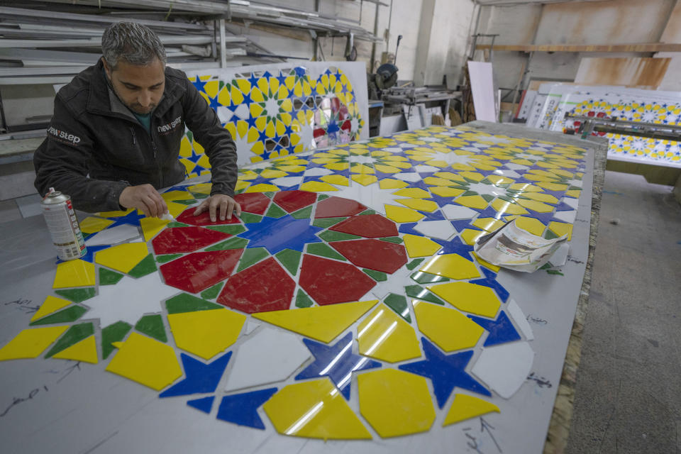 A Palestinian craftsman works on a section of an Islamic style monument that consists of lantern and a crescent, two symbolic icons of the Islamic holy month of Ramadan, in the West Bank city of Ramallah, Tuesday, March 29, 2022. The monument is built by the municipality of Ramallah to decorate a main square at the center of the city, where it will be illuminated during a mass event to celebrate the upcoming Ramadan. (AP Photo/Nasser Nasser)