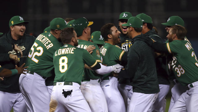 Oakland Athletics’ Ramon Laureano, center, celebrates after making the game winning hit against the Detroit Tigers in the 13th inning of a baseball game Friday, Aug. 3, 2018, in Oakland, Calif. (AP)