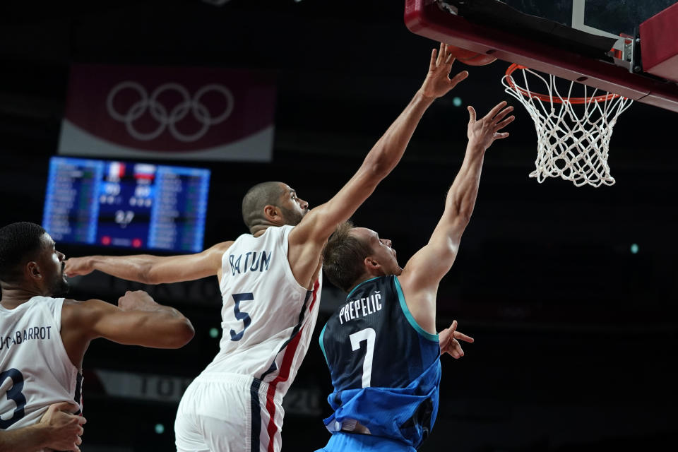 France's Nicolas Batum (5) blocks a shot by Slovenia's Klemen Prepelic (7) during a men's basketball semifinal round game at the 2020 Summer Olympics, Thursday, Aug. 5, 2021, in Saitama, Japan. (AP Photo/Charlie Neibergall)