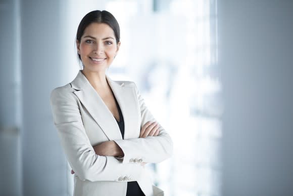 woman in business suit smiling with arms crossed