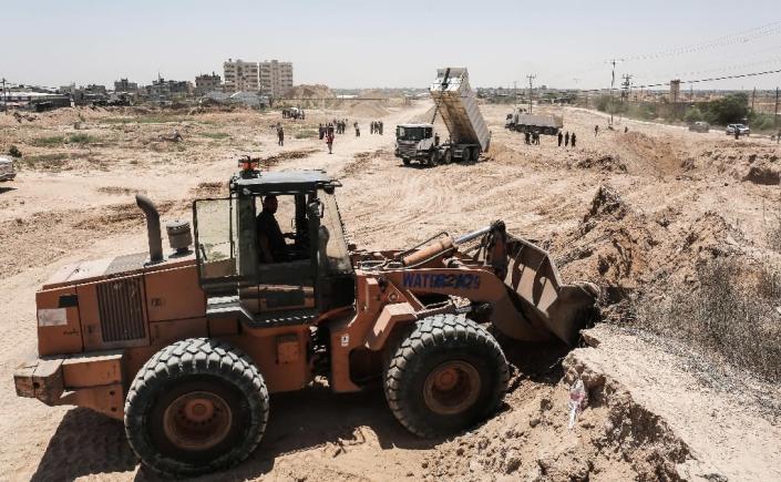 Palestinian bulldozers clear an area as Hamas begins creating a buffer zone along the border with Egypt in the southern Gaza Strip town of Rafah, on June 28, 2017 (AFP Photo/SAID KHATIB)