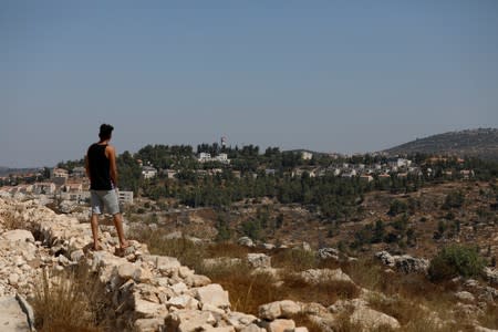 Man stands near the scene of an explosion near the Jewish settlement of Dolev in the Israeli-occupied West Bank