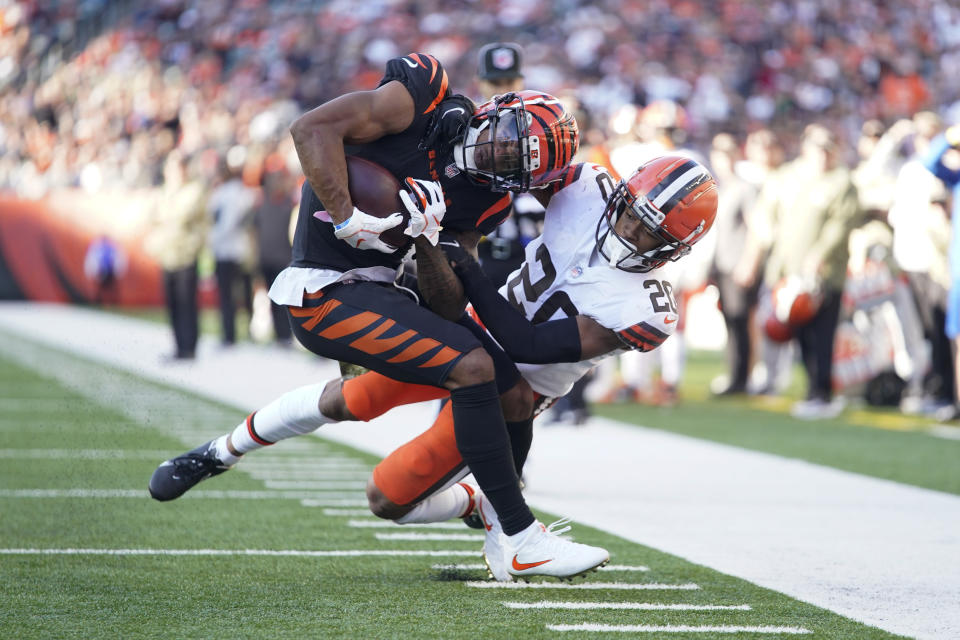 Cincinnati Bengals' Ja'Marr Chase (1) is tackled by Cleveland Browns' Greg Newsome II (20) during the second half of an NFL football game, Sunday, Nov. 7, 2021, in Cincinnati. (AP Photo/Bryan Woolston)