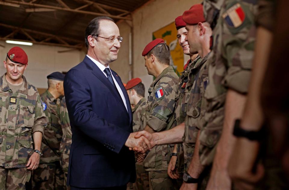 French president Francois Hollande, front left, greets French troops as he arrives at the French military operation headquarters at M'Poko airport in Bangui, Central African Republic, Friday, Feb. 28, 2014. It is Hollande's second trip to Bangui since the beginning of Operation Sangaris in December. Thousands of international troops dispatched to volatile Central African Republic are there to help keep the country from breaking apart, France's president said Friday, days after the French parliament voted to prolong the country's mission in its former colony wracked by violence between Christians and Muslims. (AP Photo/Frederic Lafargue)