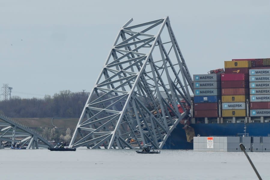 Boats move near a container ship as it rests against wreckage of the Francis Scott Key Bridge on Tuesday, March 26, 2024, as seen from Dundalk, Md. The ship rammed into the major bridge in Baltimore early Tuesday, causing it to collapse in a matter of seconds and creating a terrifying scene as several vehicles plunged into the chilly river below. (AP Photo/Matt Rourke)