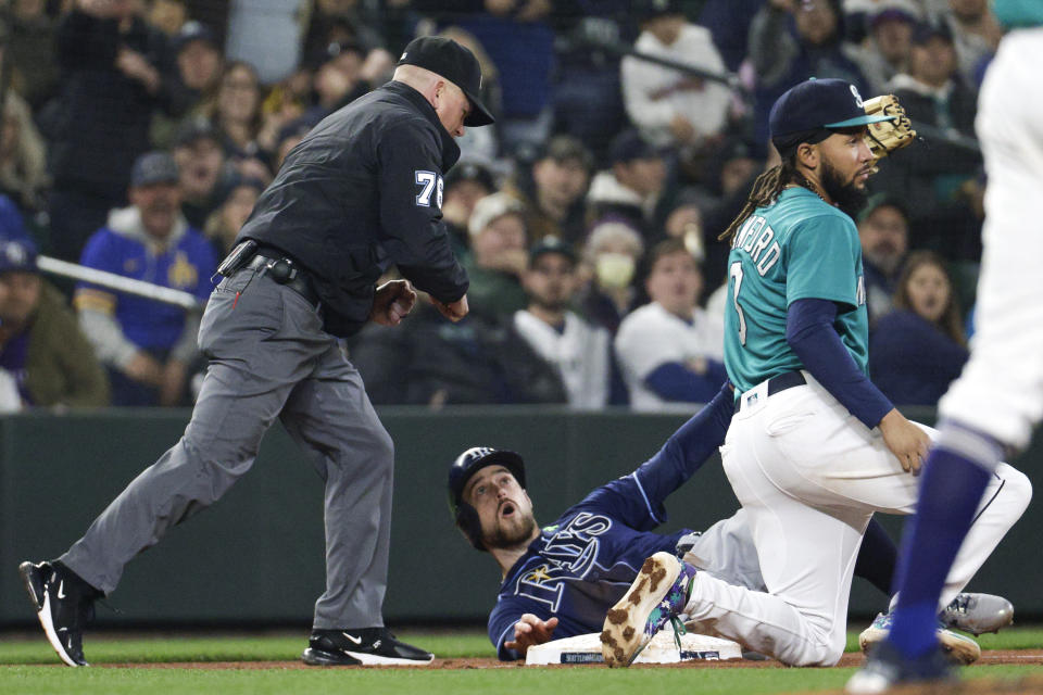 Tampa Bay Rays' Brandon Lowe is called out by third base umpire Mike Muchlinski as Seattle Mariners shortstop J.P. Crawford holds up his glove in the fifth inning of a baseball game, Friday, May 6, 2022, in Seattle. (AP Photo/Jason Redmond)
