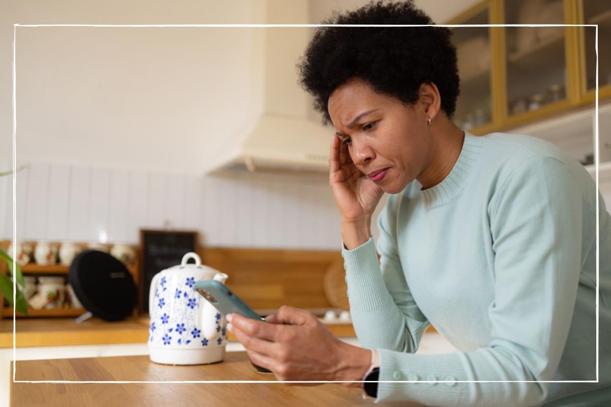  A worried woman looking at her phone. 