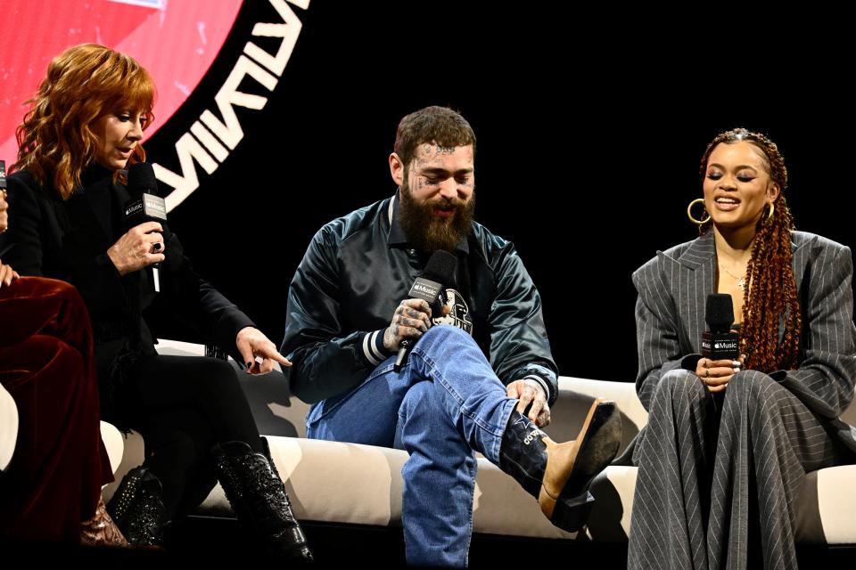 Rapper Post Malone shows his cowboy boots as he speaks with singers and actresses Reba McEntire (L) and Andra Day (R) during a press conference ahead of Super Bowl LVIII in Las Vegas, Nevada, on Feb. 8, 2024.