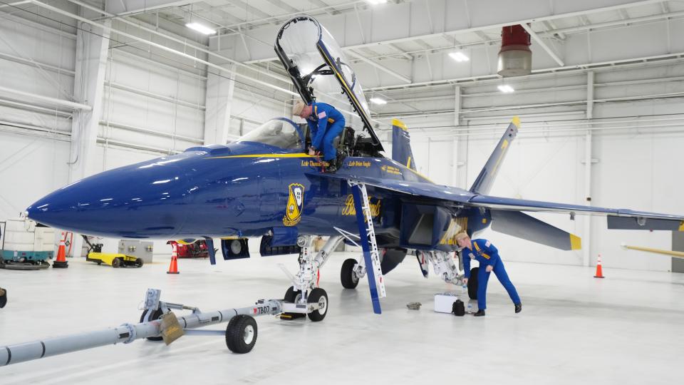 U.S. Navy LCDR's Brian Vaught (near cockpit) and Thomas Zimmerman store their Blue Angel aircraft at Rickenbacker Aviation before meeting with officials from the 2023 Columbus Air Show Presented by Scotts.