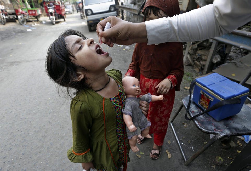 FILE - A health worker gives an oral polio vaccine to a girl on a street in Lahore, Pakistan, June 27, 2022. For years, global health officials have used billions of drops of an oral vaccine in a remarkably effective campaign aimed at wiping out polio in its last remaining strongholds — typically, poor, politically unstable corners of the world. Now, in a surprising twist in the decades-long effort to eradicate the virus, authorities in Jerusalem, New York and London have discovered evidence that polio is spreading there. The source of the virus? The oral vaccine itself. (AP Photo/K.M. Chaudary, File)