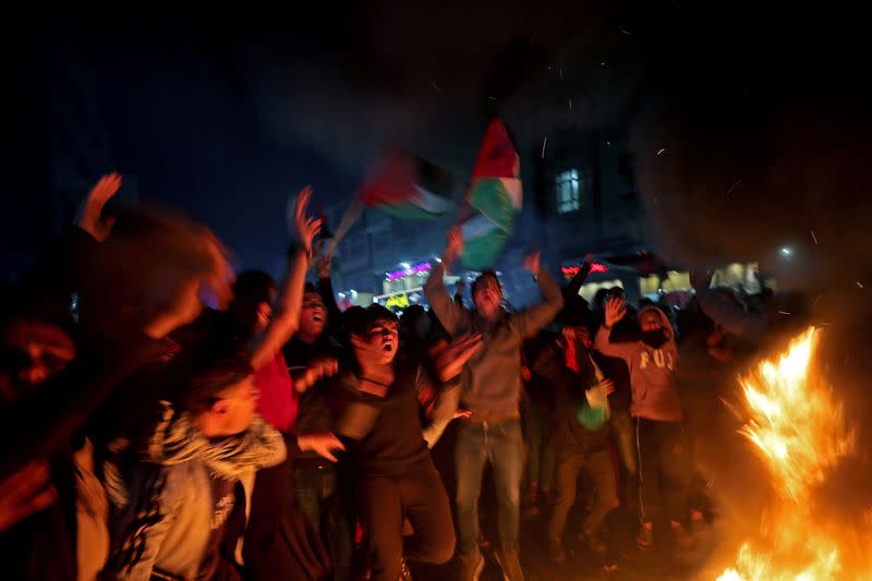 Palestinian demonstrators react as tires burn during a protest against the U.S. President Donald Trump's Mideast peace plan, in the northern Gaza Strip