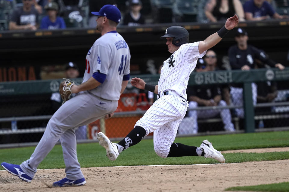 Chicago White Sox's Andrew Vaughn, right, scores on a wild pitch by Los Angeles Dodgers reliever Daniel Hudson, left, during the ninth inning of a baseball game Thursday, June 9, 2022, in Chicago. The Dodgers won 11-9. (AP Photo/Charles Rex Arbogast)