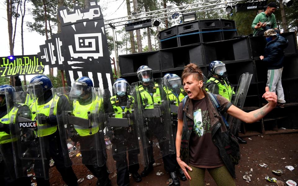 A reveller is seen in front of riot police at the scene of a suspected illegal rave, in Thetford Forest - Toby Melville/Reuters