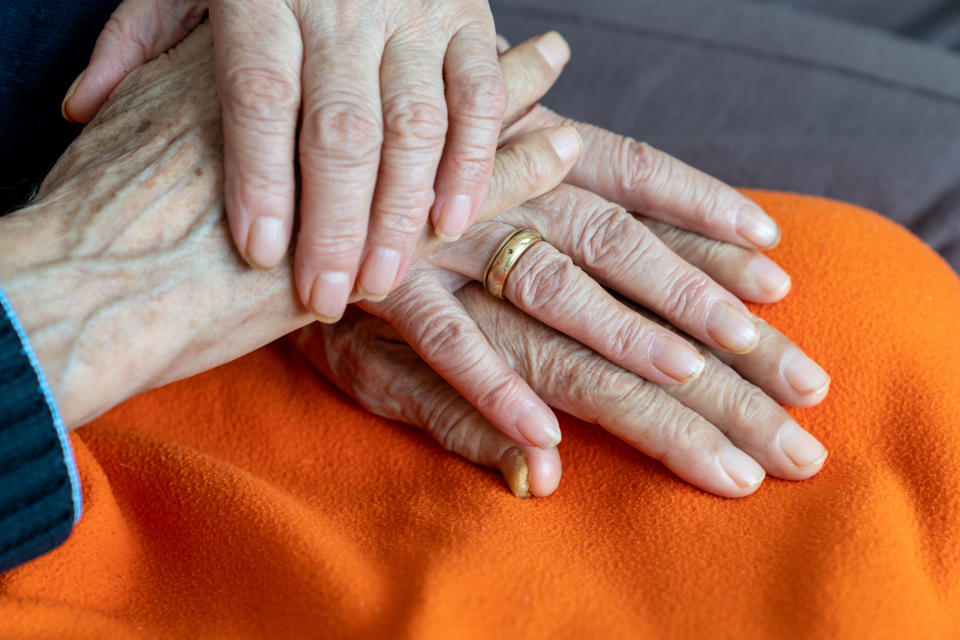 elder couple holding hands