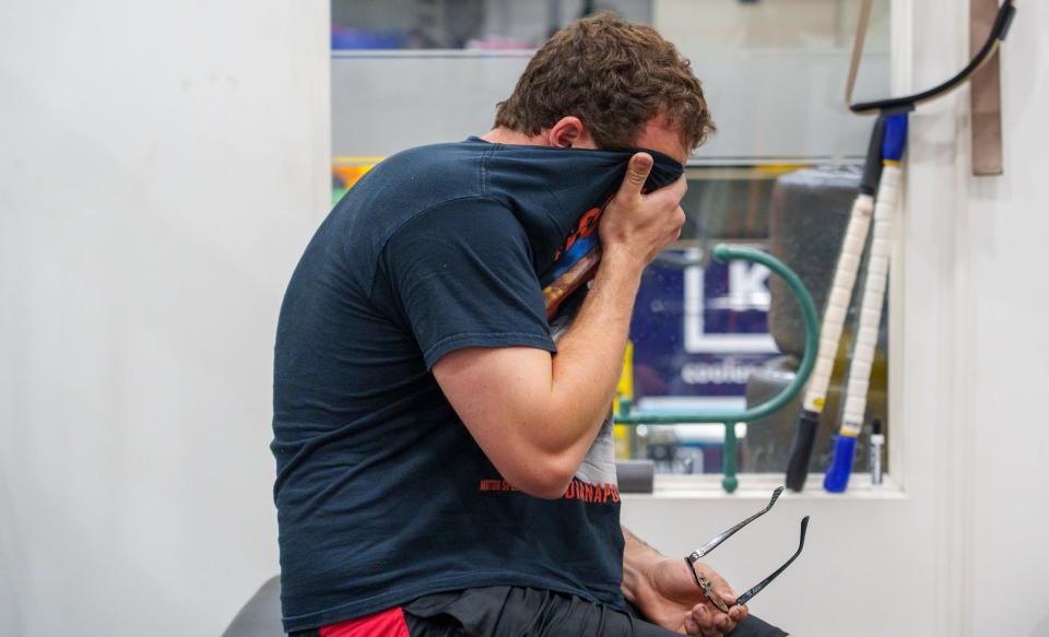 Keith Gummer, an inside rear pit crew member on the team of Andretti Autosport driver Colton Herta, wipes his face of sweat after stretching his back after using a row machine Tuesday, May 9, 2023, during a cardio day of training at the Indianapolis facility.