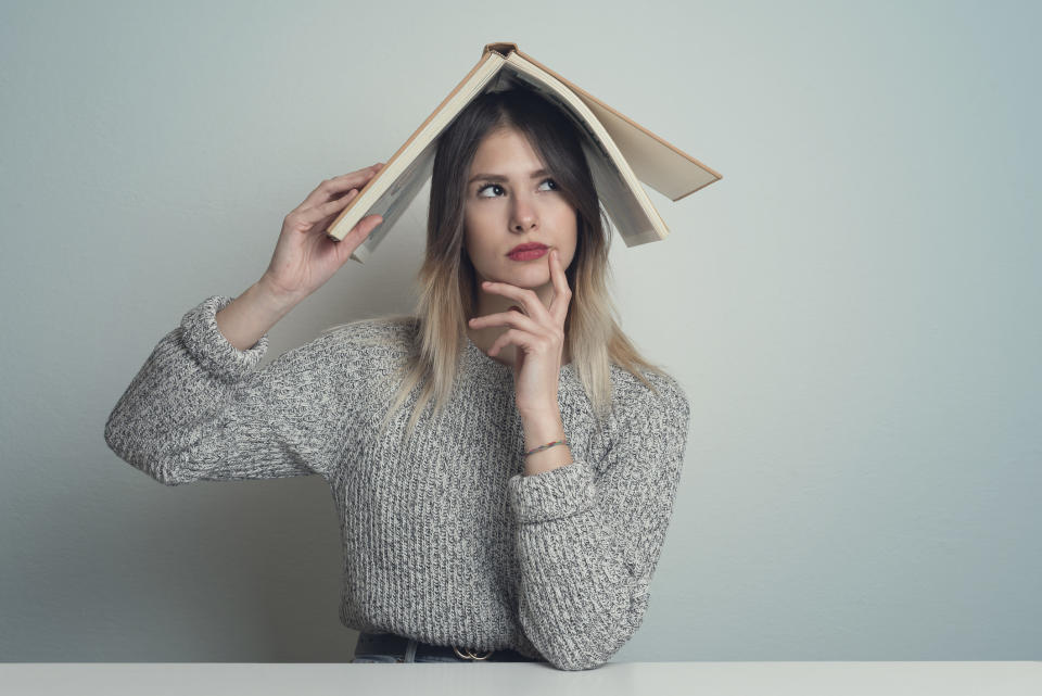 confused student with a book on her head