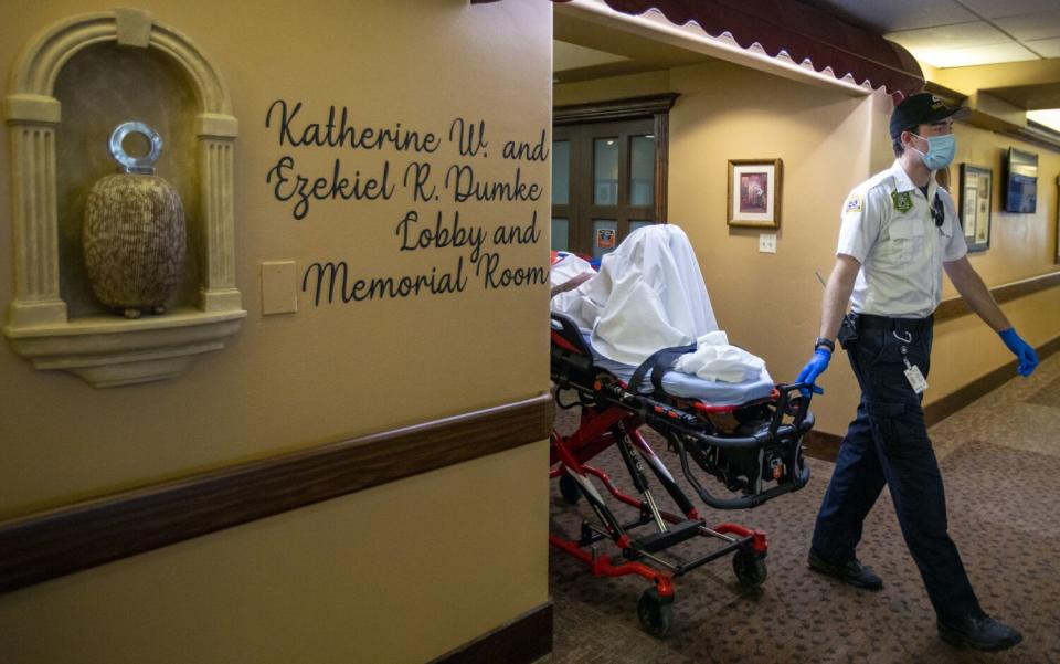 A resident is wheeled out on a gurney at the Inn Between to an ambulance in Salt Lake City.