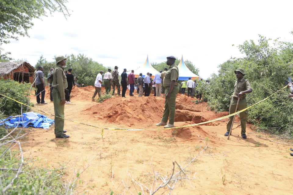 Police officers stand near a cordon at the scene where police are exhuming bodies of victims of Christian cult that has led to death of dozens of followers, at a forest in Shakahola area, outskirts of Malindi town, Kenyan Coast Tuesday, April 25, 2023. Kenya's president William Ruto said Monday that the starvation deaths of dozens of followers of pastor Paul Mackenzie, who was arrested on suspicion of telling his followers to fast to death in order to meet Jesus, is akin to terrorism (AP Photo)