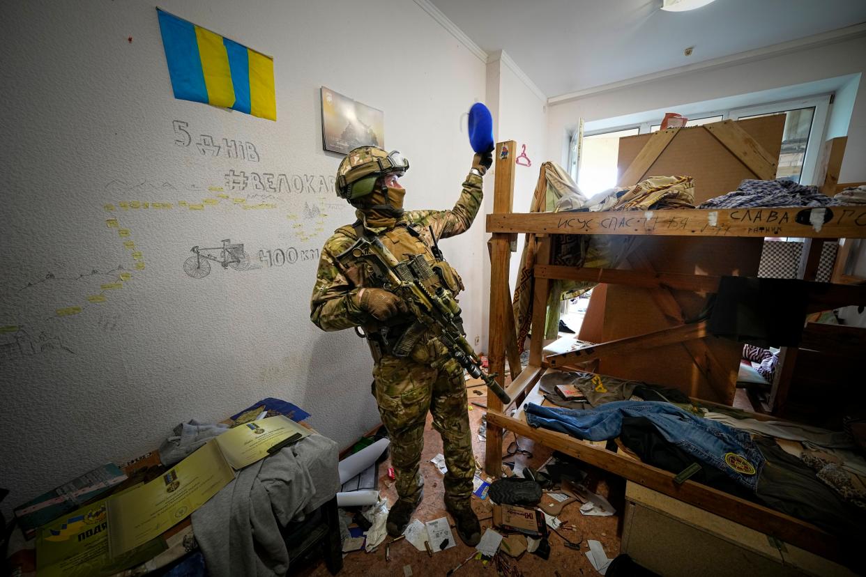 A Russian soldier walks inside the Ukraine's Azov Regiment base adorned with the unit's emblems in Yuriivka resort settlement on the coast of Azov Sea not far from Mariupol.