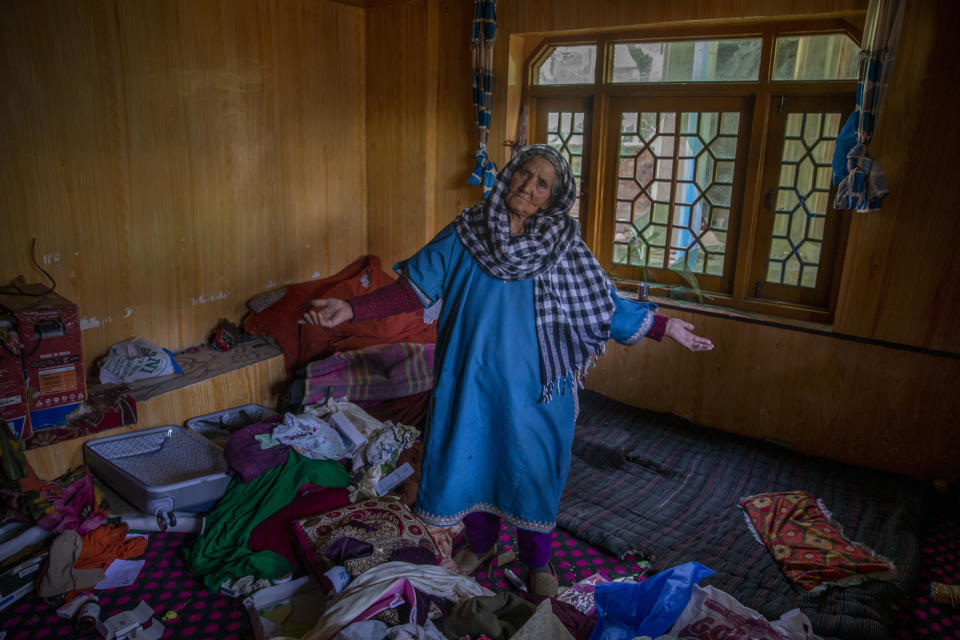 A Kashmiri woman stands amid belongings in a house allegedly ransacked by security forces after suspected militants killed a policeman in Beerwah area, Indian controlled Kashmir, Friday, Feb. 19, 2021. Anti-India rebels in Indian-controlled Kashmir killed two police officers in an attack Friday in the disputed region's main city, officials said. Elsewhere in the Himalayan region, three suspected rebels and a policeman were killed in two gunbattles. (AP Photo/Dar Yasin)