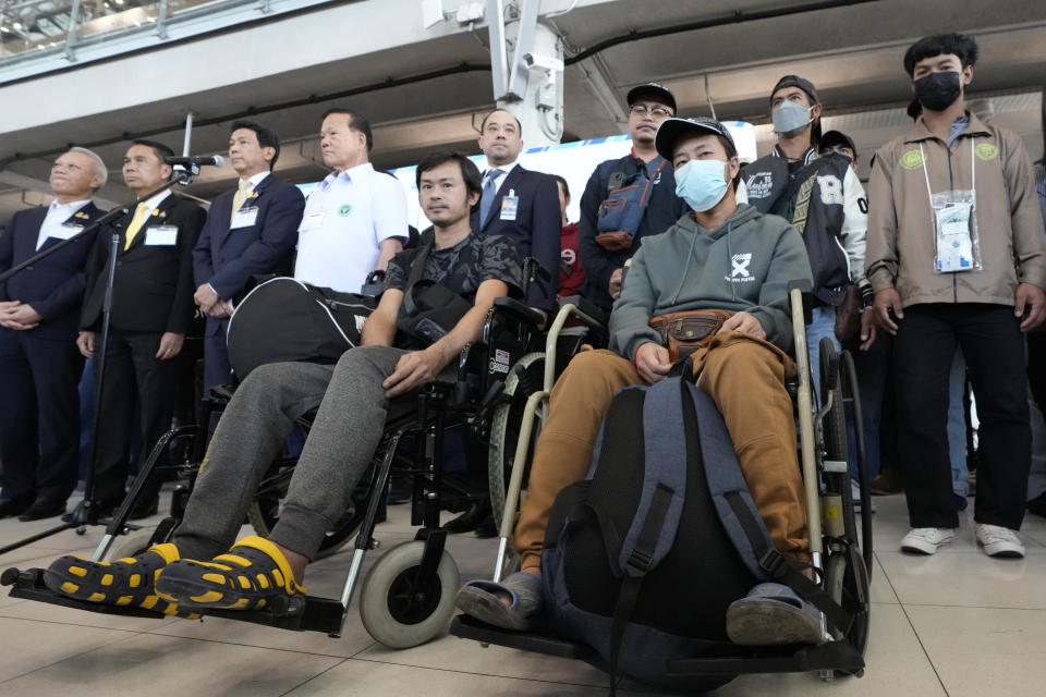 Thai Foreign Ministry Parnpree Bahiddha-Nukara, third left, talks to reporters with injured Thai overseas workers who were evacuated from Israel, as they arrive at Suvarnabhumi International Airport, in Samut Prakarn Province, Thailand, Thursday, Oct. 12, 2023. The first Thai nationals evacuated since the latest war between Israel and Hamas returned home Thursday. (AP Photo/Sakchai Lalit)