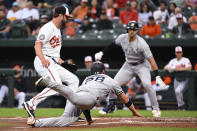 New York Yankees' Josh Donaldson scores on a wild pitch by Baltimore Orioles' Jordan Lyles, left, during the first inning of a baseball game Wednesday, May 18, 2022, in Baltimore. (AP Photo/Terrance Williams)
