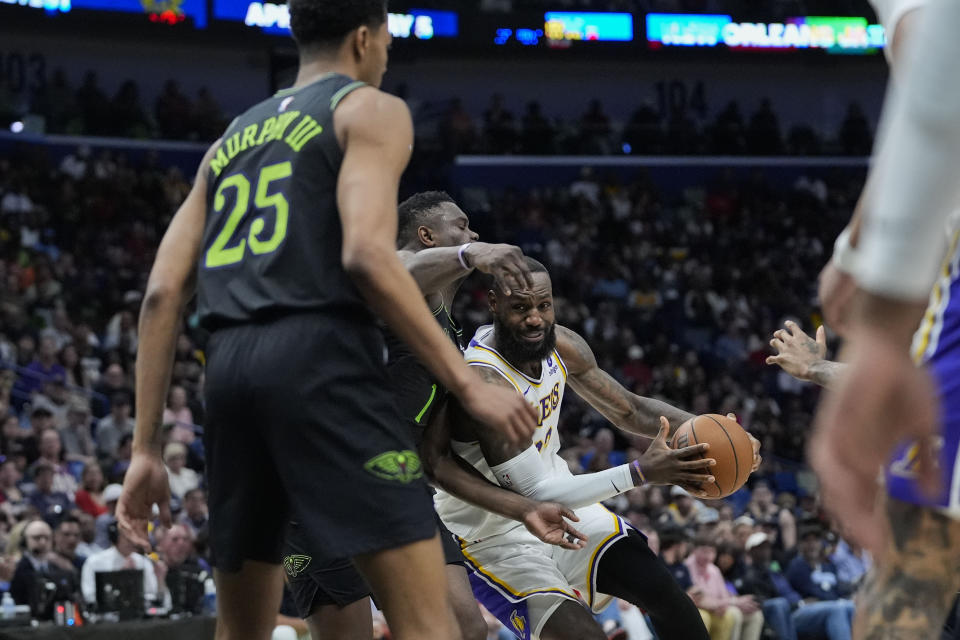 Los Angeles Lakers forward LeBron James (23) drives to the basket against New Orleans Pelicans forward Zion Williamson and guard Trey Murphy III (25) in the first half of an NBA basketball game in New Orleans, Sunday, April 14, 2024. (AP Photo/Gerald Herbert)