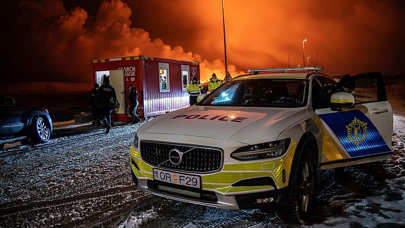 A police vehicle is parked at the entrance of the road to Grindavík with the eruption in the background, near Grindavik on Iceland&apos;s Reykjanes Peninsula, 18 December 2023.