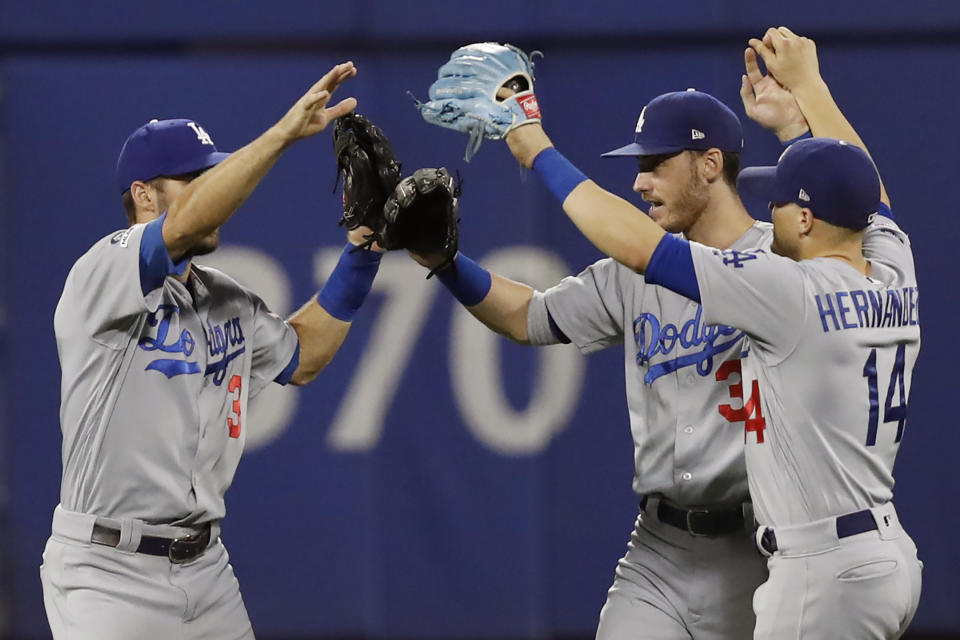 Los Angeles Dodgers left fielder Chris Taylor, left, center fielder Cody Bellinger, center, and Dodgers right fielder Enrique Hernandez (14) celebrate the Dodgers' 3-2 victory over the New York Mets in a baseball game, Sunday, Sept. 15, 2019, in New York. (AP Photo/Kathy Willens)