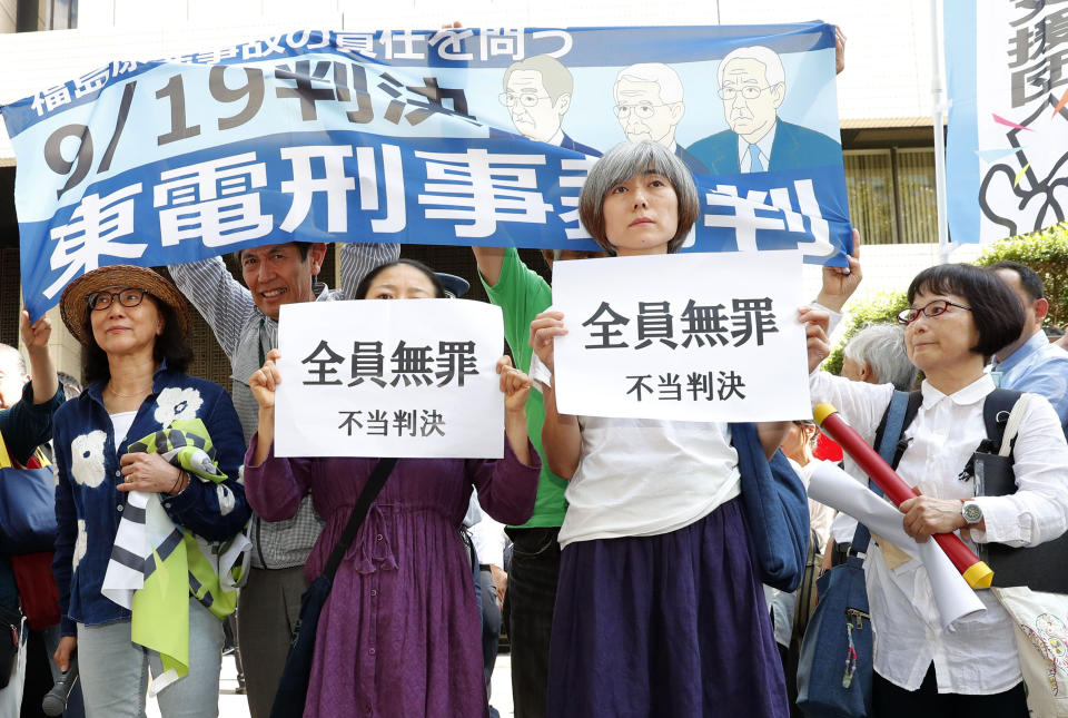 A group of supporters of the trial shows banners reading "unjust sentence" in front of Tokyo District Court in Tokyo Thursday, Sept. 19, 2019. The court on Thursday ruled that three former executives for Tokyo Electric Power Company were not guilty of professional negligence in the 2011 Fukushima meltdown. It was the only criminal trial in the nuclear disaster that has kept tens of thousands of residents away from their homes because of lingering radiation contamination. (Satoru Yonemaru/Kyodo News via AP)