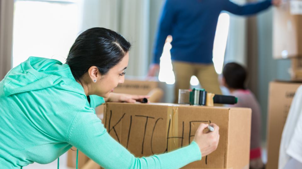 Woman labels a moving box. - SDI Productions/iStockphoto