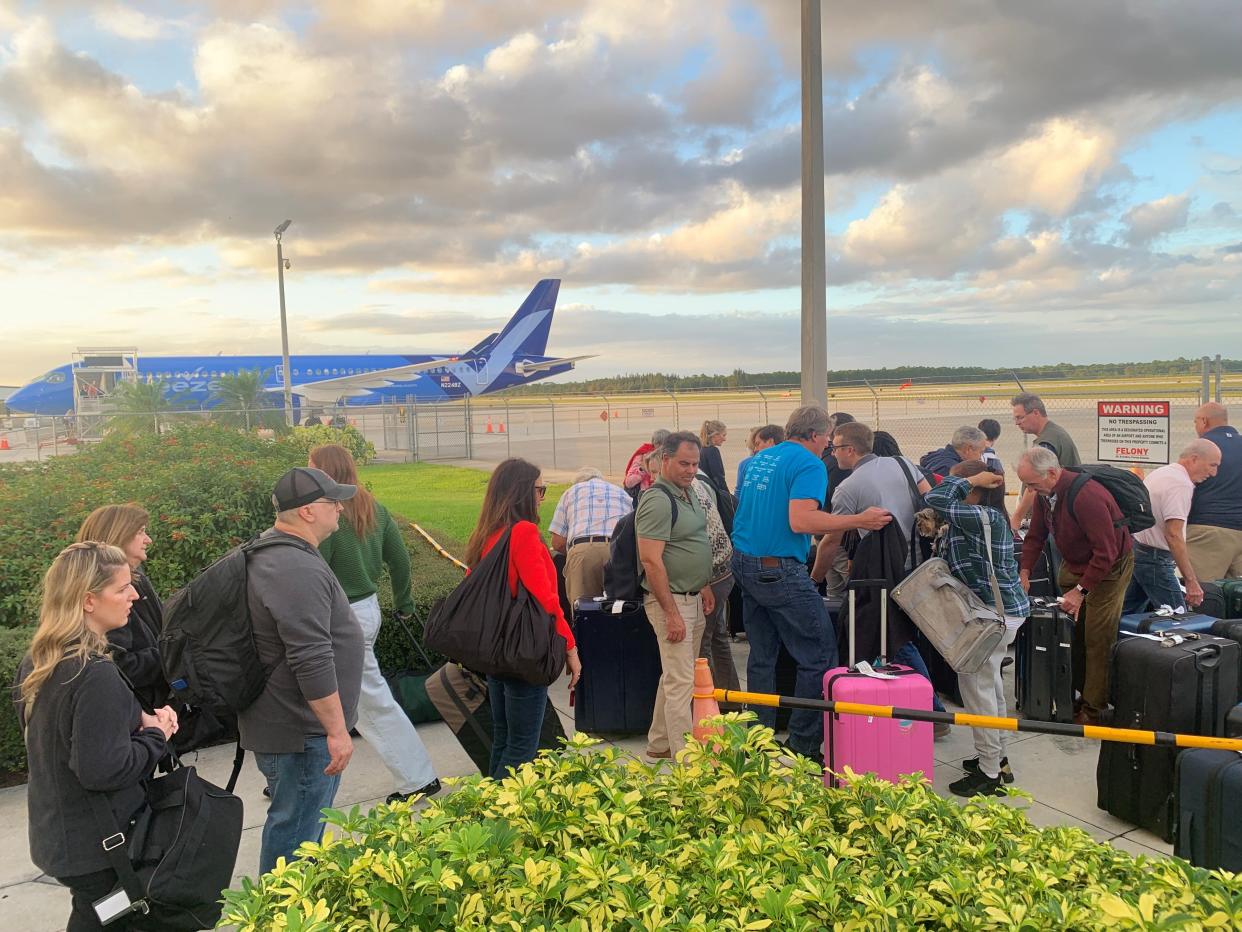 Passengers from a nearly full Breeze Airways flight from Westchester County Airport, New York, retrieve checked baggage from a makeshift outdoor holding area just inside the Vero Beach Regional Airport tarmac Nov. 20, 2023.