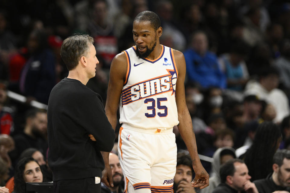 Phoenix Suns forward Kevin Durant (35) talks with Washington Wizards interim head coach Brian Keefe, left, during the first half of an NBA basketball game, Sunday, Feb. 4, 2024, in Washington. (AP Photo/Nick Wass)