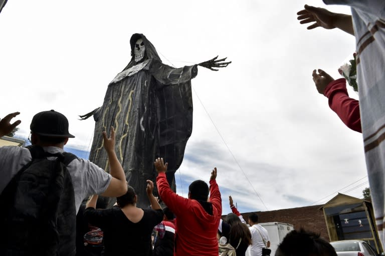 Devotees pray in front of a figure of the Santa Muerte (Holy Death) d at a sanctuary in Santa Maria Cuautepec, Tultitlan, Mexico on February 7, 2016