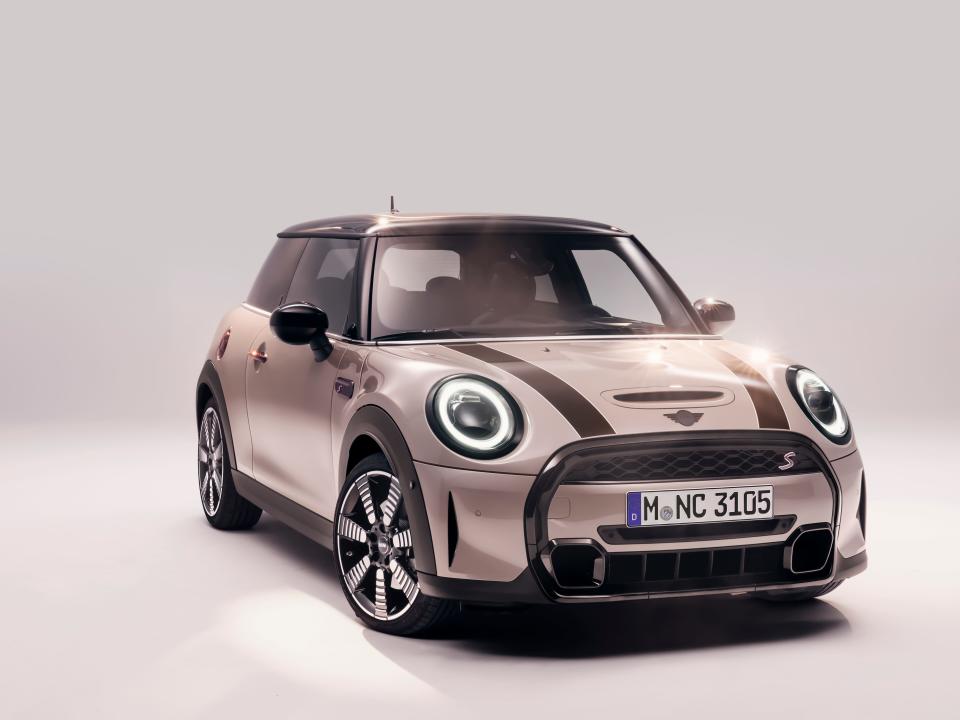 A MINI car sits in an empty room with ambient lighting.