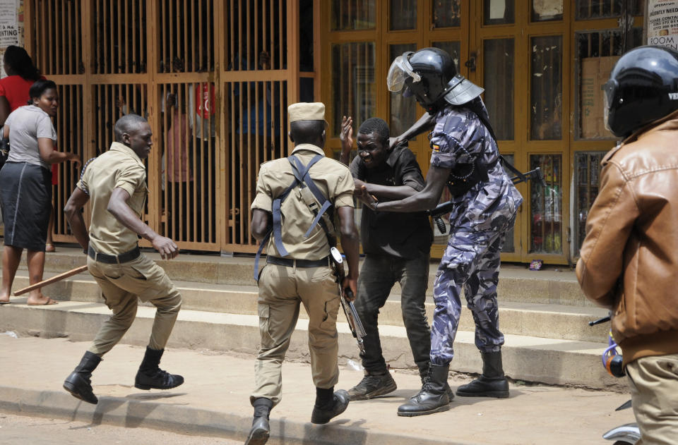 Ugandan security forces briefly beat then detain a protester in downtown Kampala, Uganda, Monday, Aug. 20, 2018. Ugandan police fired bullets and tear gas to disperse a crowd of protesters demanding the release of jailed lawmaker, pop star, and government critic Kyagulanyi Ssentamu, whose stage name is Bobi Wine. (AP Photo/Ronald Kabuubi)