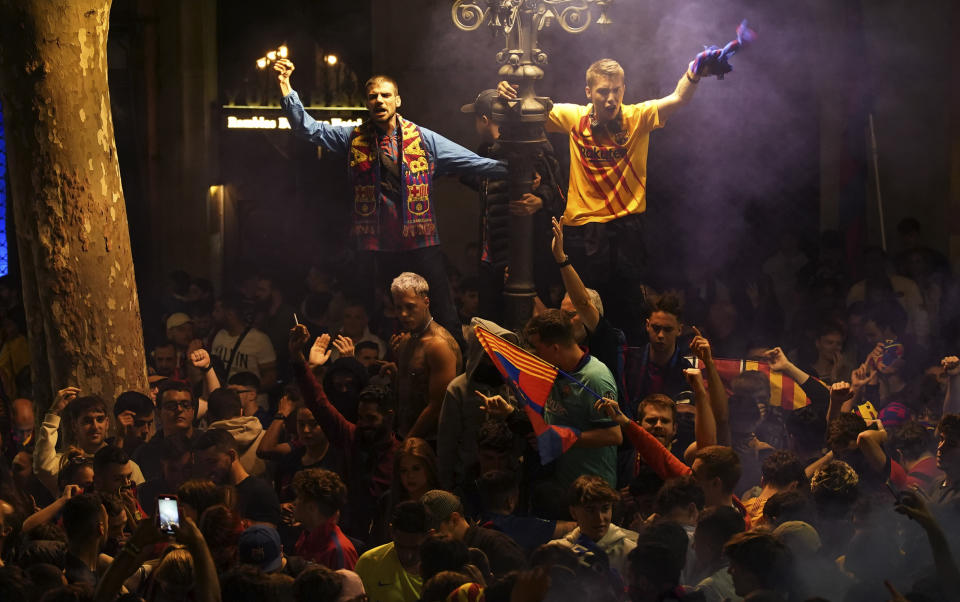 Barcelona fans celebrate in the street after their team won the Spanish La Liga championship by beating crosstown rivals Espanyol in Barcelona, Spain, Sunday May 14, 2023. (AP Photo/Joan Mateu Parra)