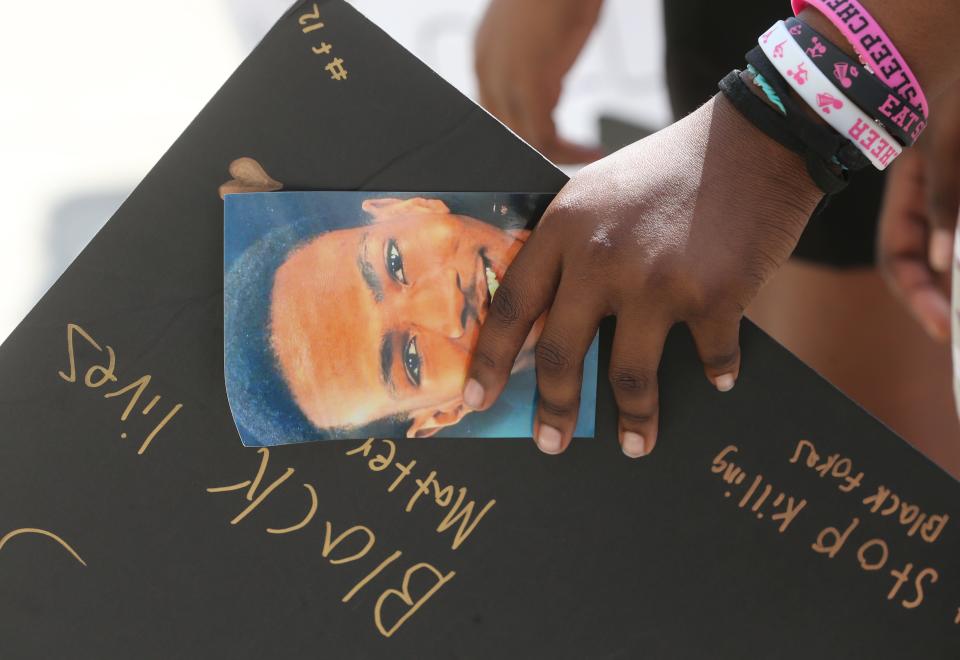 A protester holds a photo of Jayland Walker after police released bodycam footage Sunday of the 25-year-old's fatal shooting.