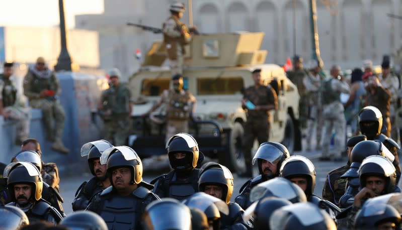 Riot police stand at Al Shuhada bridge during ongoing anti-government protests, in Baghdad