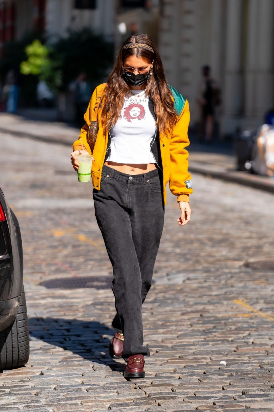 Bella Hadid walking in New York wearing a yellow jacket and jeans