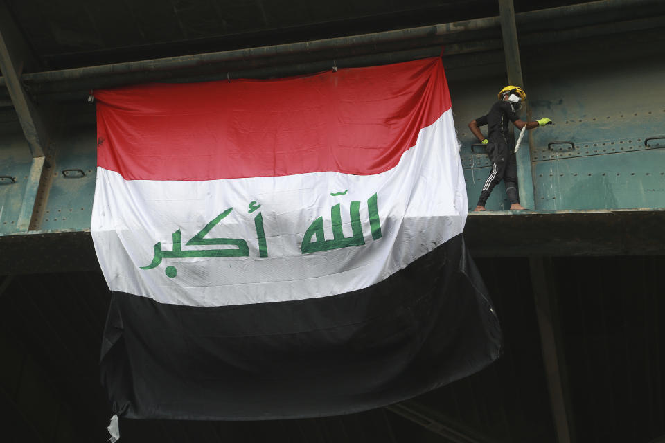 An anti-government protester climbs the Joumhouriya Bridge that leads to the Green Zone government area, during ongoing protests in Baghdad, Iraq, Sunday, Nov. 3, 2019. (AP Photo/Hadi Mizban)