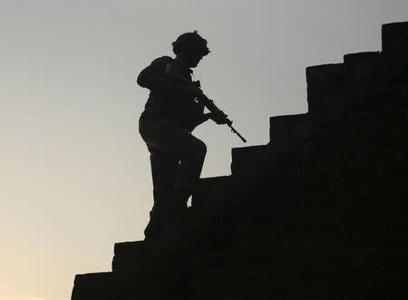 An Indian army soldier climbs up stairs to take his position on the rooftop of a residential house outside the Indian Air Force (IAF) base at Pathankot in Punjab, India, January 3, 2016. REUTERS/Mukesh Gupta