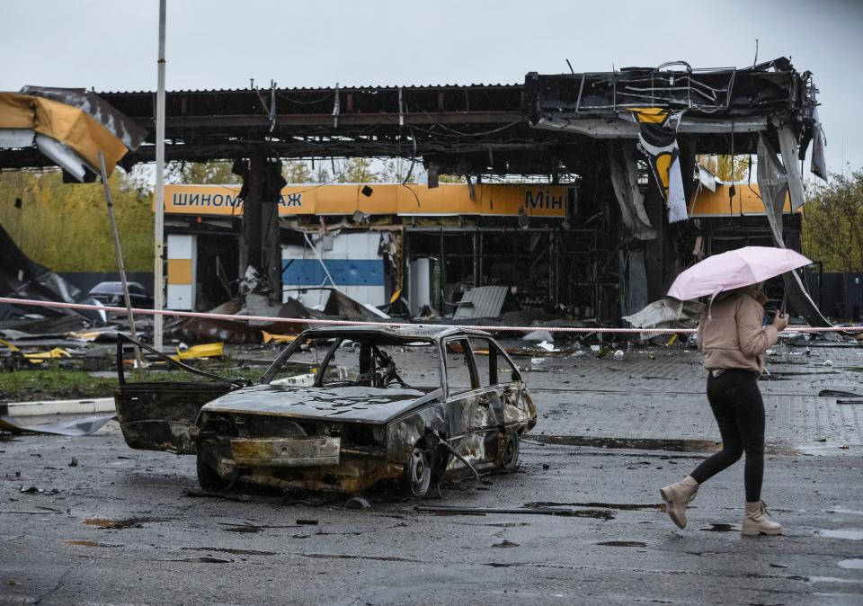 A woman passes by a gas station destroyed by yesterday’s strike on a petrol station in Dnipro (Reuters)