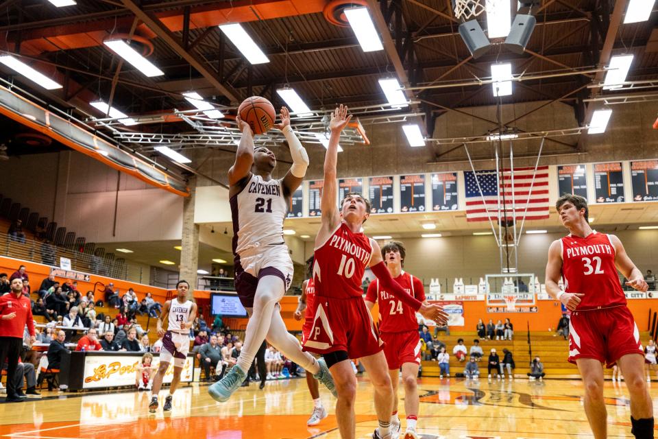 Mishawaka's Arthur Jones (21) goes up for a shot as Plymouth's Trey Hall (10) defends during the Plymouth-Mishawaka high school 4A sectional basketball game on Tuesday, February 28, 2023, at LaPorte High School in LaPorte, Indiana.